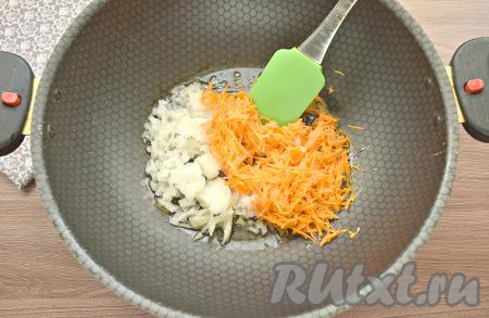 Рис промываем, перекладываем крупу в кастрюлю с достаточно большим количеством кипящей воды, подсаливаем, перемешиваем и отвариваем с момента закипания на небольшом огне до полуготовности (в течение 12 минут), затем откидываем рис на сито, чтобы слить воду, оставляем остывать. Пока рис остывает, подготовим остальные ингредиенты. Очищаем морковку и лук. Нарезаем лук на маленькие кусочки, натираем морковь на средней тёрке, а затем перекладываем эти овощи в сковороду с разогретым растительным маслом, обжариваем 5-6 минут на среднем огне, помешивая.