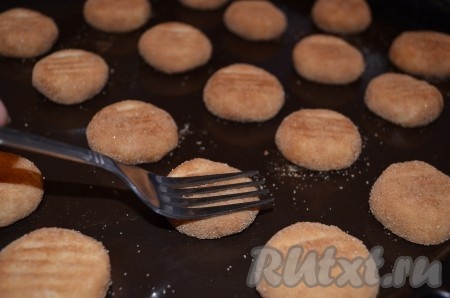 Выложить шарики (у меня обычно получается 25-30 штук) на некотором расстоянии друг от друга на противень, смазанный маслом (или застеленный пергаментом). Каждый шарик сверху немного придавить вилкой. Выпекать печенье "Сникердудль" 10-12 минут в духовке, разогретой до 180 градусов, а затем остудить его на решётке.
