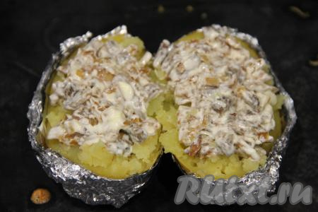 Смешать обжаренные грибы с майонезом и выложить начинку поверх горячей картошки.