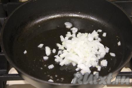 Растительное масло разогреть в сковороде, затем выложить лук и обжаривать его 3-4 минуты, помешивая, на среднем огне.