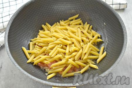 Затем на сковороду с помидорами и луком высыпаем макароны.