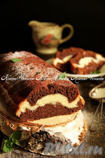 Выпекать шоколадный кекс с творожной начинкой в разогретой духовке минут 40 при температуре 180 градусов. Проверить готовность кекса достаточно просто, проколов его сухой деревянной шпажкой (если и после прокола кекса шпажка останется сухой, на ней не будет следов теста, значит пора доставать выпечку из духовки). Достать готовый кекс из духовки, слегка остудить в форме, а затем, вынув его из форму, остудить на решётке. При подаче посыпать наивкуснейший кекс сахарной пудрой. Посмотрите, какой красивый разрез у этой выпечки!