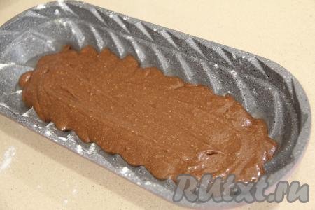 Для выпечки этого кекса я взяла литую форму размером 14 сантиметров на 32 сантиметра. Литую форму, также как и силиконовую, перед выкладыванием теста можно не смазывать маслом, остальные виды форм желательно смазывать маслом. В форму выложить половину шоколадного теста.