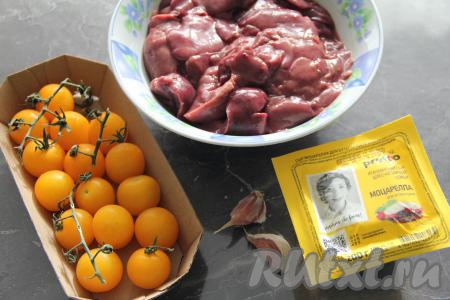 Подготовить продукты для приготовления куриной печень под шубой в духовке. Печень промыть водой, разрезать на две части. Чеснок почистить, помидоры вымыть.