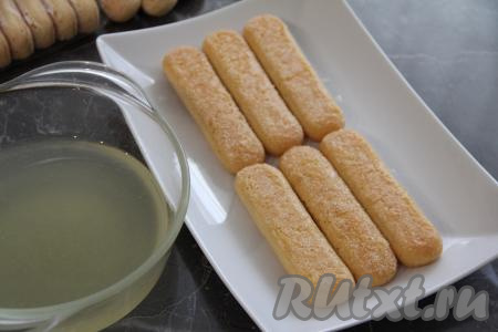 Печенье "Савоярди" окунать в подготовленный лимонный сироп, а затем выкладывать на тарелку, на которой будете формировать тирамису (первым слоем я выложила 6 пропитанных савоярди).