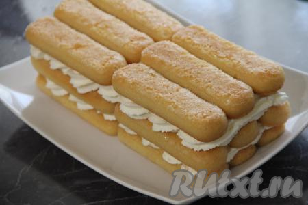 Выложить следующий слой пропитанного в сиропе печенья савоярди и снова слой крема. Таким образом сформировать три слоя.