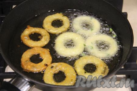 Жарить картофельные колечки на среднем огне до лёгкого золотистого цвета с двух сторон. Затем переложить на бумажное полотенца. Постепенно пожарить все кольца.