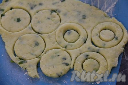 Раскатать картофельное тесто на припылённой мукой поверхности в пласт толщиной примерно 1 см. Вырезать колечки.&nbsp;