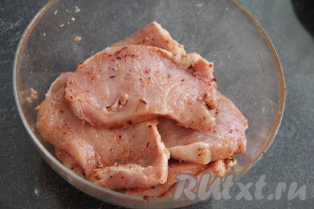 Для получения маринада соединить 2 столовых ложки растительного масла, специи и пропущенный через пресс чеснок, перемешать. Хорошо обмазать каждую отбивную маринадом со всех сторон. Сложить мясо, смазанное маринадом, в миску и отставить в сторону.