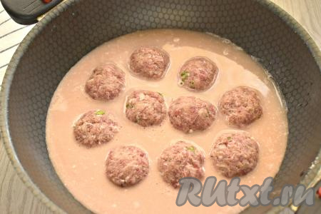 Отдельно смешиваем сметану, томатную пасту и 300 миллилитров тёплой воды, немного солим и перчим, тщательно перемешиваем и вливаем получившийся соус к тефтелям на сковороду. Соус должен покрыть тефтели почти полностью.