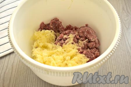 Кабачок очищаем от кожуры и семян (если семечки мелкие, их можно оставить). 250 грамм очищенного кабачка натираем на средней тёрке, отжимаем от сока (сок от кабачка нам не понадобится). Получившуюся кабачковую массу и фарш перекладываем в миску.