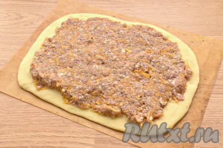 Начинку из фарша и тыквы распределяем равномерно по раскатанному тесту, немного отступая от краёв.
