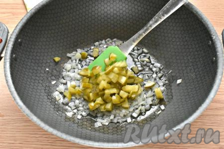 Добавляем к обжаренному луку нарезанные огурцы, перемешиваем и обжариваем овощи, помешивая, минуты 3-4.