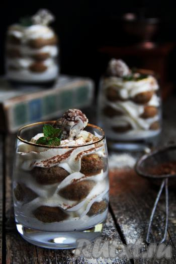 А затем верх трайфлов "Тирамису", сформированных в стаканчиках с печеньем "Савоярди", по желанию, украсить и подавать вкусный, нежный десерт к столу.