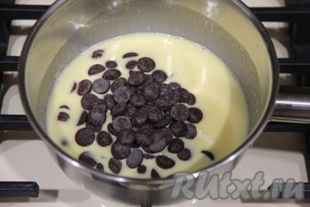 В сотейник выложить сливочное масло и растопить его на среднем огне, затем всыпать шоколадные капли (или шоколад, поломанный на кусочки), перемешать и, помешивая, довести до полного растворения шоколада, снять с огня, дать шоколадно-масляной массе немного остыть.