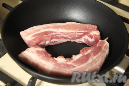 Сковороду разогреть, выложить в неё кусочки грудинки.