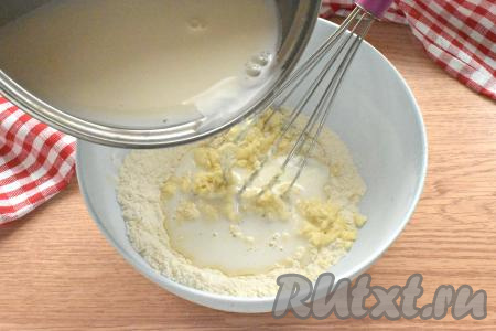 В это тесто небольшими порциями,&nbsp;интенсивно перемешивая венчиком, начинаем вливать горячее молоко.