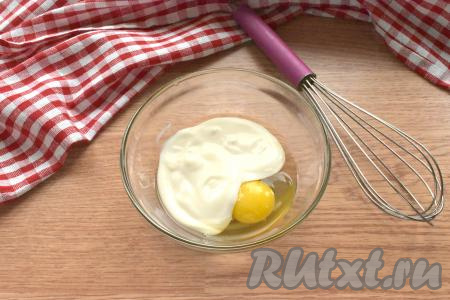 В отдельную миску перекладываем сметану, добавляем яйцо, перемешиваем венчиком до получения однородной смеси.
