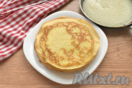 Спустя это время приступаем к жарке блинов. Смазываем сковороду маслом и очень хорошо разогреваем. Выливаем на сковороду половник блинного теста, распределяя по всему дну сковороды. Жарим блинчик с каждой стороны по минуте (до подрумянивания) на среднем огне, затем перекладываем на тарелку. Сковороду больше смазывать не нужно, ведь масло уже есть в тесте. Постепенно жарим все блинчики. Тесто периодически перемешиваем, ведь оно оседает на дно миски. Я готовила блины на сковороде диметром 18 сантиметров, у меня получилось 13 штук.