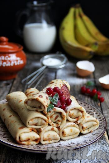 Готовые вкусные, нежные блинчики с начинкой из бананов и яблок переложить на тарелку и подать к столу. По желанию, перед подачей можно прогреть блины в микроволновке в течение 2 минут или обжарить на сковороде со сливочным маслом, чтобы начинка хорошо скрепилась.