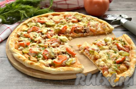 Пицца на слоёном тесте с курицей получилась вкусной и очень аппетитной. Разрезаем её на порции и сразу угощаемся.