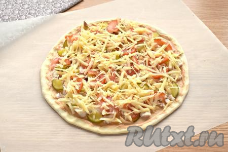 Посыпаем пиццу натёртым сыром.