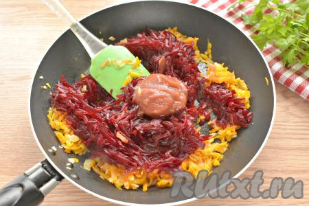 Варёную свеклу натираем на крупной тёрке, выкладываем к моркови и луку, сразу же добавляем столовую ложку томатной пасты, перемешиваем.