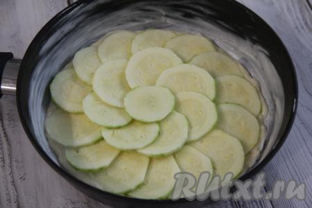 С кабачка снять шкурку и нарезать на тонкие кружочки. Выложить кружочки кабачка внахлёст поверх теста.