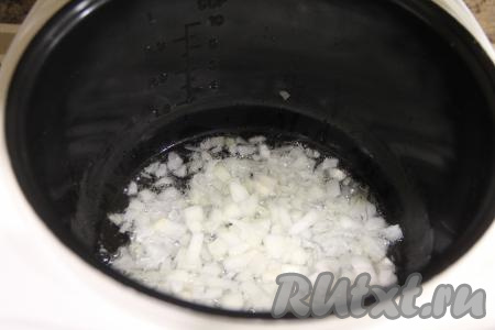 В чашу мультиварки влить масло. Луковицу почистить и мелко нарезать. Выставить режим "Жарка". Выложить лук в чашу мультиварки и жарить, не закрывая крышку, минут 5, периодически помешивая.