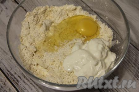 Перетереть массу руками в крошку. Добавить сметану и сырое яйцо.