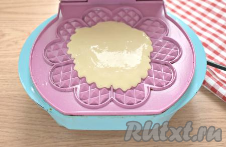 Разогреваем поверхность электровафельницы, при необходимости, смазываем её маслом. Выкладываем в центр 2-3 столовых ложки теста, закрываем крышку.