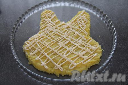 Поверх картошки тонкой сеточкой на нести майонез.