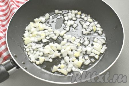 Очищаем репчатый лук и нарезаем его на кусочки. 2 столовые ложки растительного масла разогреваем на сковороде, выкладываем лук, обжариваем его на среднем огне 2-3 минуты, помешивая.