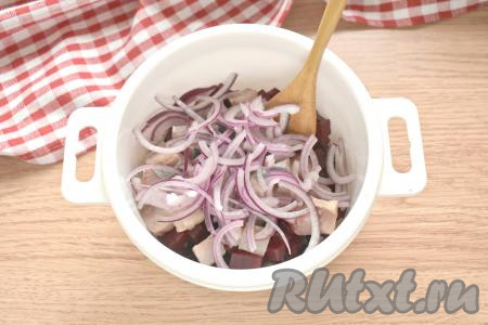 Нарезаем половину очищенной луковицы на тонкие полукольца и добавляем к сельди со свеклой.