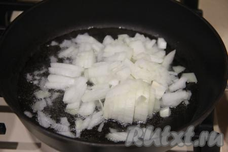 В сковороду влить растительное масло, немного прогреть его и выложить мелко нарезанный лук, обжарить его на среднем огне минуты 3, иногда перемешивая.