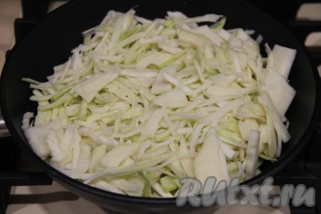 Переложить обжаренный фарш со сковороды на тарелку, а в сковороду влить ещё немного масла и выложить нарезанную капусту. Жарить капусту минут 15 (до мягкости), периодически перемешивая, на среднем огне.