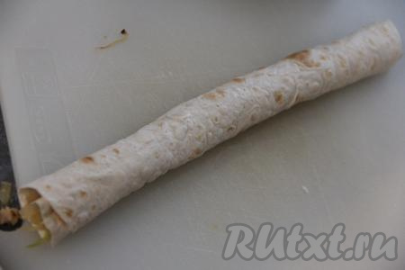 Лаваш нарезать на длинные полоски шириной примерно 13-15 сантиметров. На край длинной стороны одной полоски из лаваша выложить часть начинки из фарша с капустой, свернуть полоску из лаваша в плотный рулетик, начиная сворачивать со стороны с начинкой. Таким образом использовать весь лаваш и большую часть начинки. Оставшуюся начинку я использовала в дальнейшем при формировании пирога.