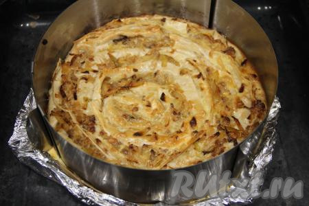 Готовый пирог из лаваша с капустой и фаршем достать из духовки, слегка остудить, затем снять бортики формы.
