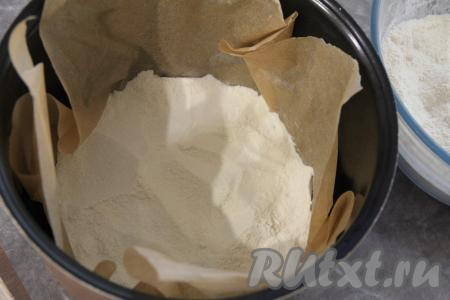 Чашу мультиварки выстелить пергаментом. Выложить треть смеси сухих ингредиентов на дно застеленной чаши мультиварки.