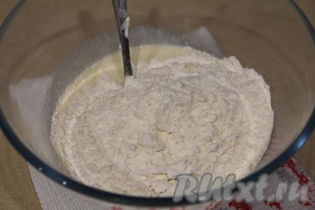 Всыпать частями муку, замешивая тесто для торта вначале ложкой, затем - руками. Долго тесто вымешивать не нужно, главное, чтобы оно собралось в ком, стало нежным и пластичным.