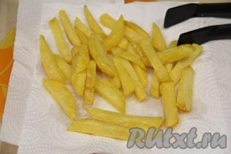 Достать готовую картошку фри из чаши мультиварки и выложить на бумажное полотенце. Опустить следующую порцию картофеля во фритюр. Таким образом пожарить всю картошку.