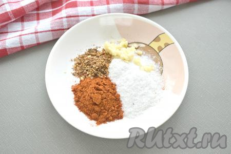 Через трое суток кусочки сала достаём из рассола и обсушиваем их бумажными полотенцами. Для получения обмазки смешиваем в глубокой тарелке одну столовую ложку соли с паприкой, смесью молотых перцев и пропущенными через пресс пятью зубчиками чеснока, тщательно перемешиваем.