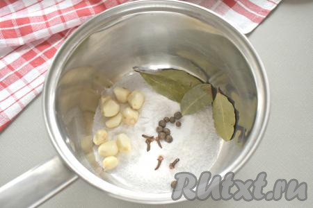 Далее нужно сварить рассол, для этого в ковшик (или небольшую кастрюльку) всыпаем 3 столовые ложки соли, добавляем 10 очищенных зубчиков чеснока, перец горошком, бутоны гвоздики и лавровые листья.