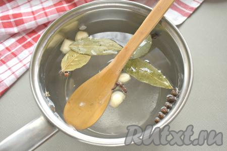 К чесноку с солью и специями вливаем 1,5 литра воды, ставим на огонь, перемешиваем, доводим рассол до кипения и провариваем его 2-3 минуты (в течение этого времени кристаллики соли полностью растворятся).