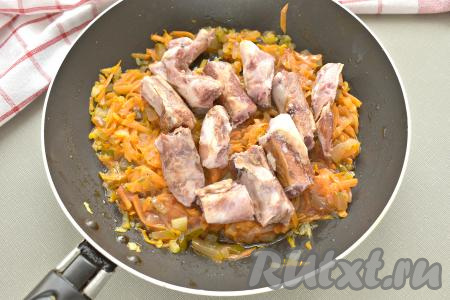 Затем в сковороду добавляем копчёные рёбрышки, перемешиваем. Крупные рёбра нужно заранее разрубить на несколько частей. Томим на сковороде 5 минут, обжаривая рёбрышки со всех сторон.