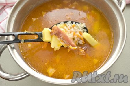 Когда рис с картошкой сварятся (станут достаточно мягкими), добавляем в кастрюлю копчёные рёбрышки с овощами со сковороды, даём закипеть, а после этого варим рассольник на небольшом огне 5 минут.