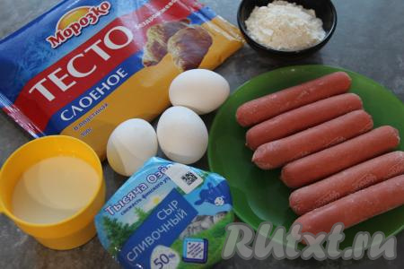 Подготовить продукты для приготовления пирога из слоёного теста с сосисками и сыром. Слоёное тесто можно взять и дрожжевое, и бездрожжевое. Сосиски очистить от слюды. Тесто разморозить при комнатной температуре.