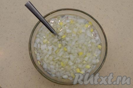 Для слоёного салата я предпочитаю мелко нарезать ингредиенты, тогда блюдо хорошо пропитывается, получается сочным и отлично режется при подаче. Лук очистить, промыть и нарезать на небольшие кусочки, переложить в небольшую пиалу, всыпать одну чайную ложку сахара, влить две чайных ложки уксуса и 50-70 миллилитров кипятка, перемешать (лук должен быть полностью покрыт маринадом). Оставить лук промариноваться минут на 15. Благодаря маринованию, лук не будет горчить и приобретёт пикантный вкус.