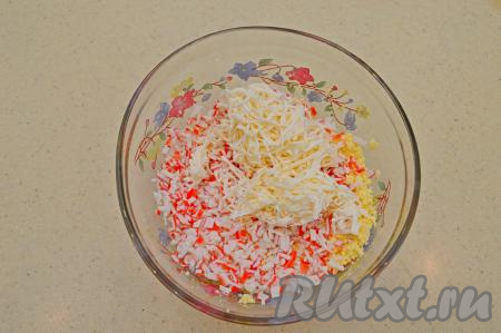 К желткам и крабовым палочкам добавить сыр, натёртый на мелкой тёрке (я взяла плавленный сырок, но подойдёт и любой сыр твёрдых сортов).