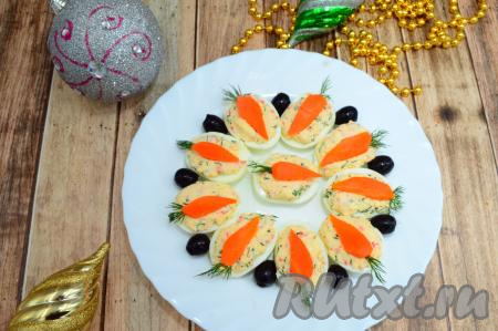 Украсить закуску по своему вкусу, я между яиц положила по маслине. Посмотрите, какой яркой, праздничной, по-настоящему новогодней получилась закуска из яиц, крабовых палочек и сыра. Кролик - хозяин наступающего года - несомненно оценит ваши старания и Новый год станет по-настоящему добрым!